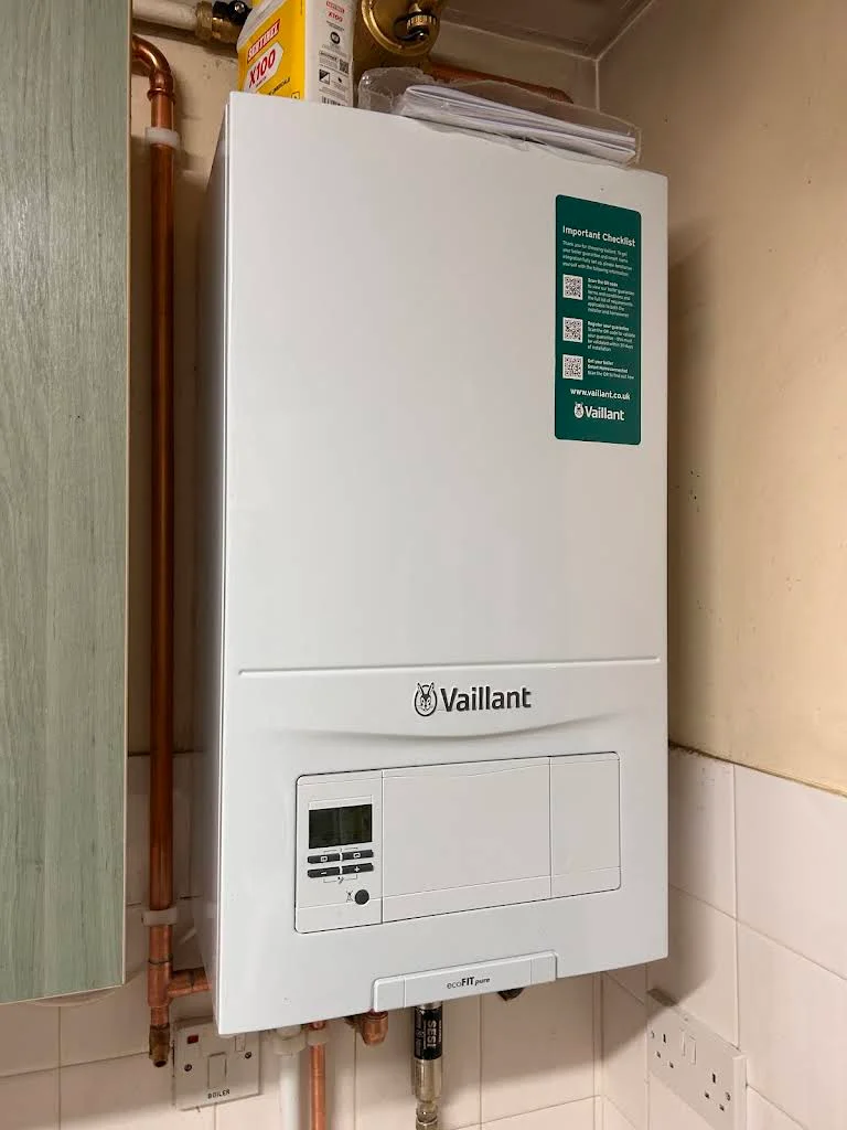 Vaillant gas boiler installed in a domestic setting, featuring a digital display and copper piping, representing energy-efficient heating solutions offered by TMS Mechanical Services in Upminster.